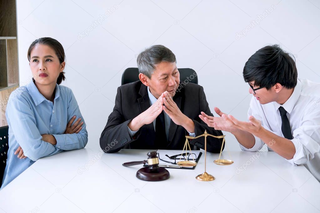 Unhappy divorce couple having conflict, Man and wife conversation during divorce process with senior male lawyer or counselor.