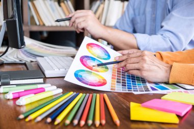 İş yerindeki grafik tabletinde renk seçimi ve çizim üzerine çalışan iki iş arkadaşı yaratıcı grafik tasarımcısı.