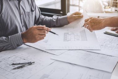 Mimar veya inşaat ve mühendislik araçları çalışma sitesi, inşaat ve yapı kavramı model üzerinde ortak çalışma projesi için toplantı planı üzerinde çalışan mühendis.