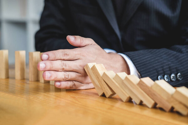 Деревянная стратегия игры, предприниматель рука остановить падение деревянные домино эффект непрерывного свержения или риска, стратегии и успешного вмешательства концепции для бизнеса
.