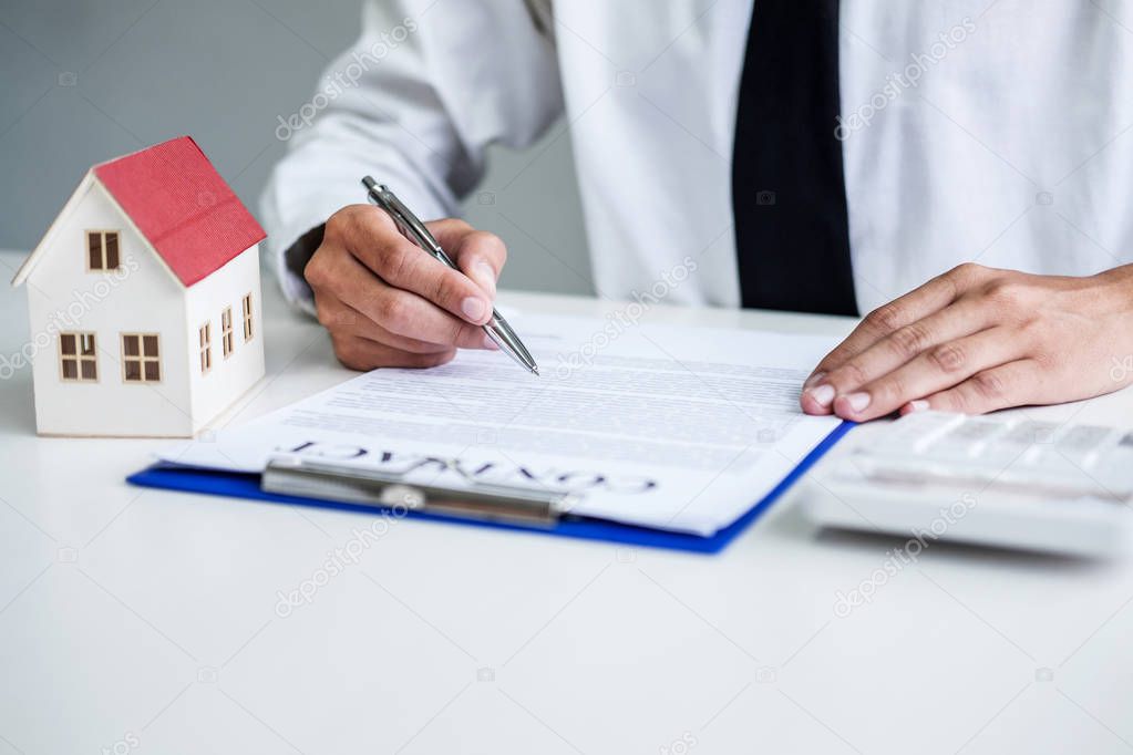 Man sign a home insurance policy on home loans, Businessman signing contract insurance.