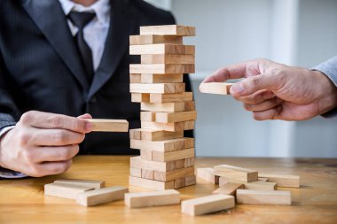 Görüntüleri el koyarak ve ahşap blok Kulesi, alternatif risk kavramı, plan ve strateji iş, Risk için yapmak iş büyüme kavramı ile ahşap bloklar çekerek iş adamları.