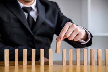 Ahşap oyun stratejisi, Risk ve iş stratejisinde kadar yakın işadamı el ahşap blok domino bir satırına yerleştirerek kumar.