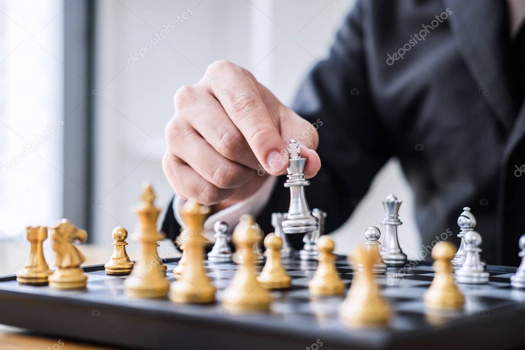 Hands of confident businessman playing chess game to development analysis new strategy plan, leader and teamwork concept for win and success.