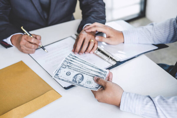 Подкуп и коррупция концепции, взятка в виде долларовых купюр, бизнесмен дает деньги при заключении сделки по заключению контракта на недвижимость и финансового учета
.