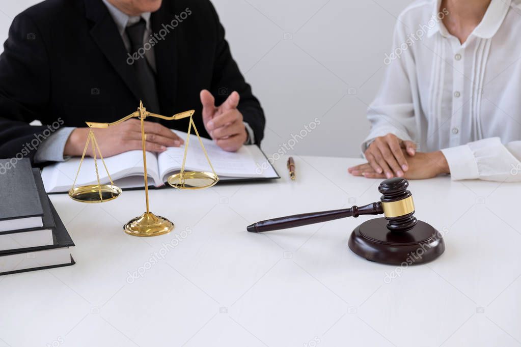 Close up of gavel, Male lawyer or judge Consult with client and working with Law books, report the case on table in modern office, Law and justice concept.
