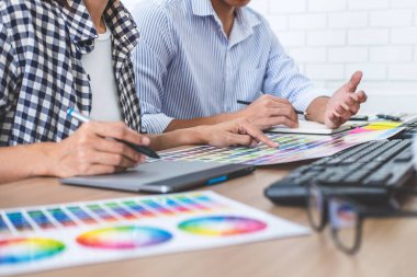 İş yerinde renk seçimi ve grafik tableti üzerinde çalışan iki iş arkadaşı yaratıcı grafik tasarımcısı, seçim renklendirmesi için renk örnekleri grafikleri çizimi.
