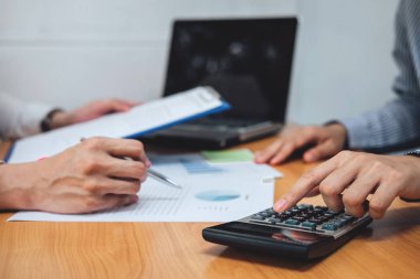 İki iş takım çalışma ve finansal yatırım hesaplama analiz iş ve Pazar büyüme ile raporda mali belge veri grafiği ve dijital tablet üzerinde tartışıyor.