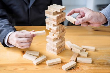Görüntüleri el koyarak ve ahşap blok Kulesi, alternatif risk kavramı, plan ve strateji iş, Risk için yapmak iş büyüme kavramı ile ahşap bloklar çekerek iş adamları.
