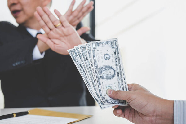 Концепция взяточничества и коррупции, отказ бизнесмена получать деньги в конверте по договору, взятка в виде долларовых купюр
.