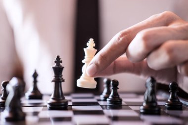 Kendine güvenen işadamı yardıma Kral satranç parça beyaz oyun satranç oyunu geliştirme analiz yeni strateji planı, şampiyonluk ve başarı için iş stratejisi.