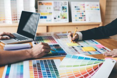 Genç yaratıcı bir toplantı yaratıcı ofis, iş araçları ve aksesuarları, renk renk örneği örnekleri grafik seçimi boyama çizim mimari sahip takım.