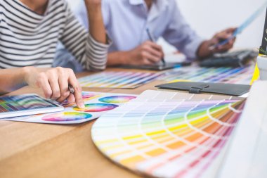 İş yerinde renk seçimi ve grafik tableti üzerinde çalışan iki iş arkadaşı yaratıcı grafik tasarımcısı, seçim renklendirmesi için renk örnekleri grafikleri çizimi.