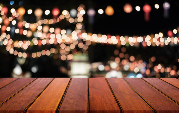Выборочный пустой деревянный стол перед абстрактным размытым праздничным светлым фоном с светлыми пятнами и боке для монтажа продукта
.