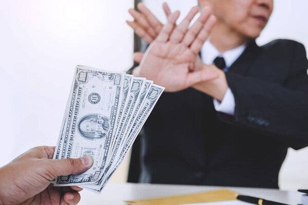 Концепция взяточничества и коррупции, отказ бизнесмена получать деньги в конверте по договору, взятка в виде долларовых купюр
.