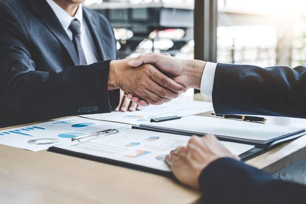 Teamwork partnership meeting concept, Two confident Business shaking hands after discussing good deal of trading contract and new projects for both companies.