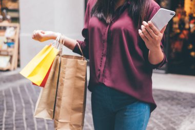 Tüketim, alışveriş, yaşam kavramı, Genç kadın holding renkli alışveriş torbaları ve akıllı telefon Alışveriş keyfi.