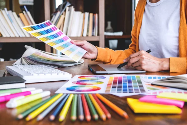 作業道具や付属品で職場のグラフィックタブレット上で色の選択と描画に取り組む女性の創造的なグラフィックデザイナーのイメージ — ストック写真