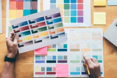 Genç yaratıcı grafik tasarımcı renk renk örneği örnekleri grafik iş araçları ve aksesuarları işyerinde boyama seçimi için seçmek için grafik tablet kullanma.