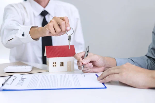 房地产销售经理签署租赁租赁合同后给客户钥匙 关于按揭贷款要约和房屋保险 — 图库照片