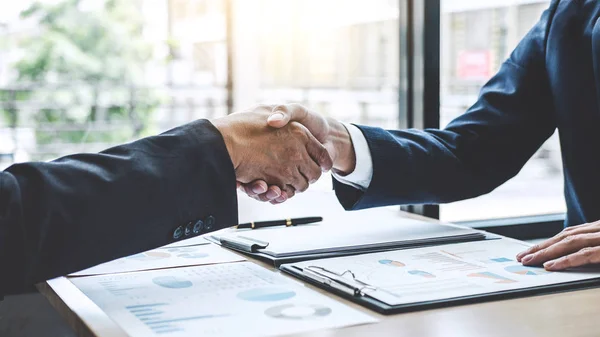 Teamwork partnership meeting concept, Two confident Business shaking hands after discussing good deal of trading contract and new projects for both companies.