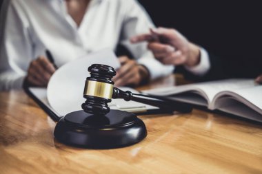 Mahkemede çalışan erkek avukat veya avukat, emlak, hukuk ve hukuk hizmetleri kavramının sözleşme belgeleriyle istişarede bulunarak müvekkilleriyle görüşür..