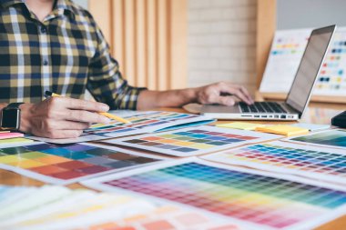Genç yaratıcı grafik tasarımcı renk renk örneği örnekleri grafik iş araçları ve aksesuarları işyerinde boyama seçimi için seçmek için grafik tablet kullanma.