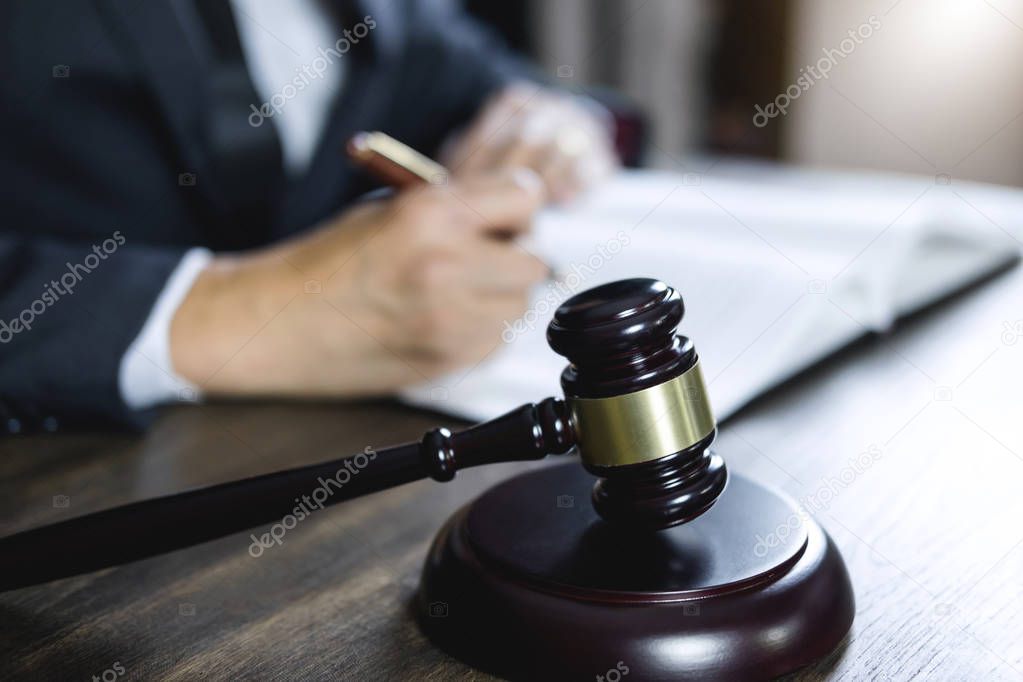 Counselor or Male lawyer working on courtroom sitting at the table. Legal law, Judge gavel with Justice lawyers advice with gavel and Scales of justice.