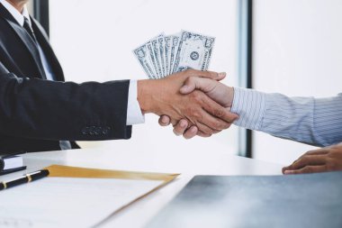 Rüşvet ve yolsuzluk kavramı, para, el sallayarak ve veren işadamı şeklinde rüşvet anlaşması için bir sözleşme anlaşma yaparken para gizler.