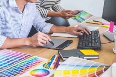 İş yerinde renk seçimi ve grafik tableti üzerinde çalışan iki iş arkadaşı yaratıcı grafik tasarımcısı, seçim renklendirmesi için renk örnekleri grafikleri çizimi.