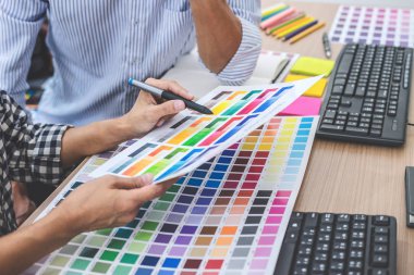 Genç yaratıcı bir toplantı yaratıcı ofis, iş araçları ve aksesuarları, renk renk örneği örnekleri grafik seçimi boyama çizim mimari sahip takım.