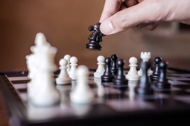 Kendine güvenen iş adamı yardıma at satranç oynayan siyah parça satranç oyunu geliştirme analiz yeni strateji planı, iş stratejisi için şampiyonluk ve başarı için.
