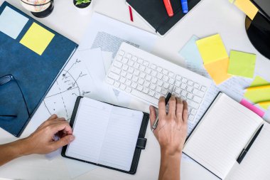 İşadamı çalışma yazı yapma Not iş planı ve bilgisayar ofis, üst ile grafik tasarımcı çalışma alanını görüntülemek.