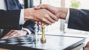 Sonra satranç oyun ulaşan oynarken son plan başarı için el sallayarak, üstesinden zorluk ve sağlanması hedefleri iş stratejisi kazanmak, yönetim ve liderlik kavramı iki iş adamı.
