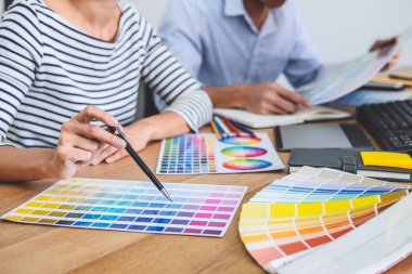 İş yerinde renk seçimi ve grafik tableti üzerinde çalışan iki iş arkadaşı yaratıcı grafik tasarımcısı, seçim renklendirmesi için renk örnekleri grafikleri çizimi.