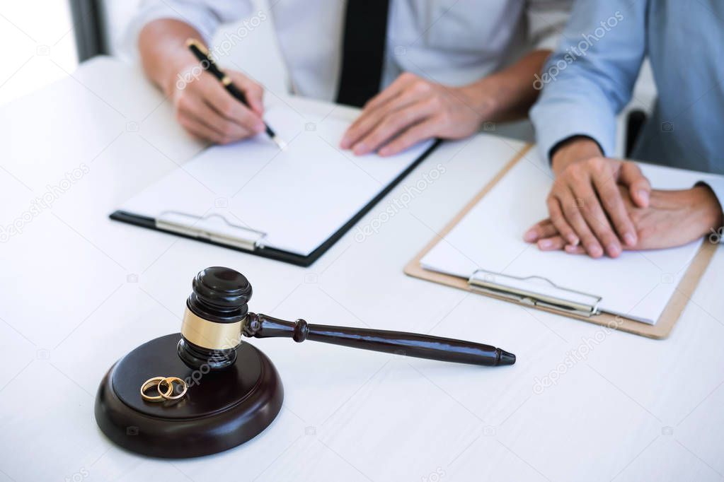 Decree of divorce (dissolution or cancellation) of marriage, husband and wife during divorce process with lawyer or counselor and signing of divorce contract.
