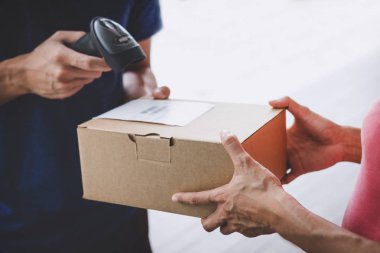 Eve teslim hizmet ve çalışma hizmet zihin, bir karton kutu paket servis kurye ve teslimatçı alma kadın müşteri el teslim onaylamak için barkod tarama.