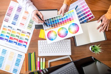 İşyerinde iş araçları ve aksesuarları, üstten görünüm çalışma alanı ile grafik tablet çizim çalışma renk seçimi ve renk örnekleri, iki meslektaşım yaratıcı grafik tasarımcı.