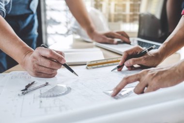 Mimar veya inşaat ve mühendislik araçları çalışma sitesi, inşaat ve yapı kavramı model üzerinde ortak çalışma projesi için toplantı planı üzerinde çalışan mühendis.