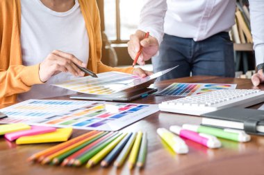 İş yerindeki grafik tabletinde renk seçimi ve çizim üzerine çalışan iki iş arkadaşı yaratıcı grafik tasarımcısı.