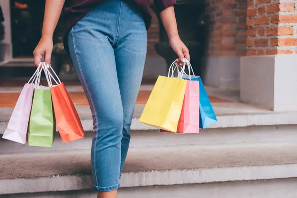 Consumer and shopping lifestyle concept, Happy young woman standing and holding colorful shopping bags enjoying great day in shopping.