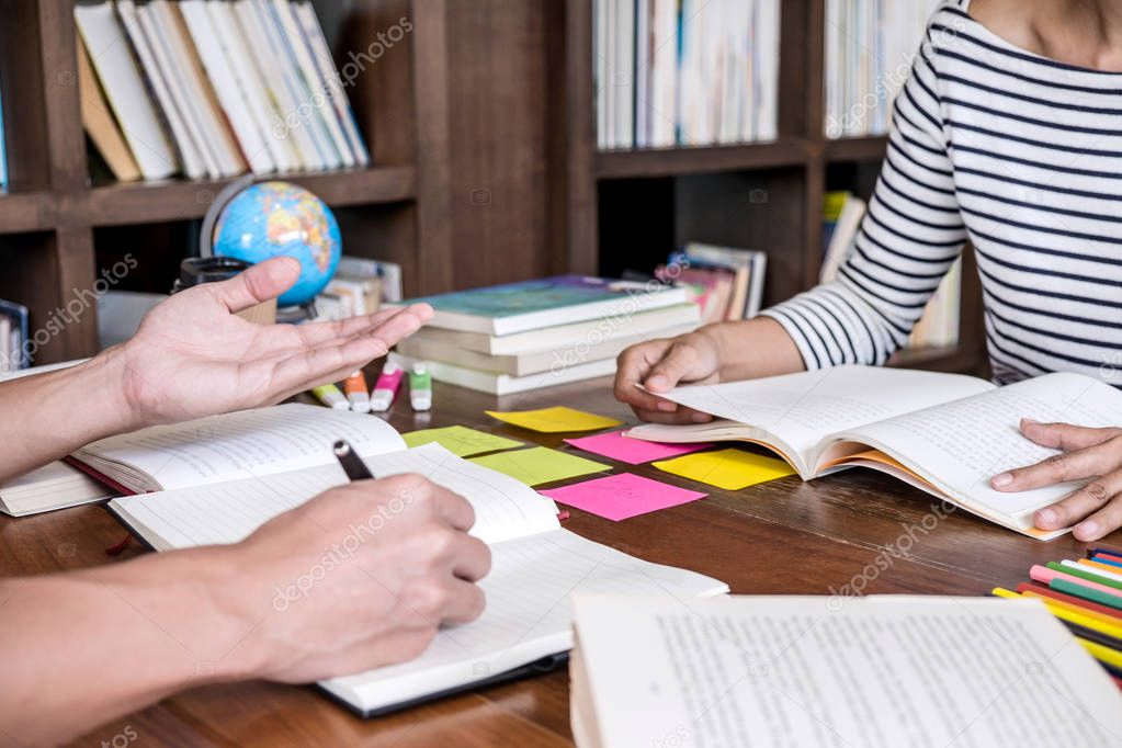 High school or college student group sitting at desk in library studying and reading, doing homework and lesson practice preparing exam to entrance, education concept.