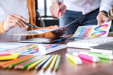 İş yerindeki grafik tabletinde renk seçimi ve çizim üzerine çalışan iki iş arkadaşı yaratıcı grafik tasarımcısı.