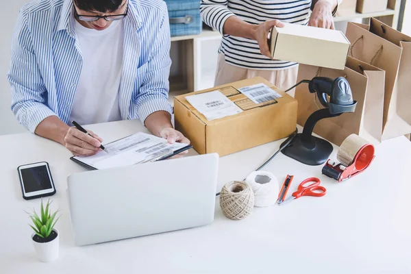 Shipment Online Sales, Small business or SME entrepreneur owner delivery service and working packing box, business owner working checking order to confirm before sending customer in post office.