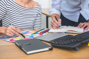 Genç yaratıcı bir toplantı yaratıcı ofis, iş araçları ve aksesuarları, renk renk örneği örnekleri grafik seçimi boyama çizim mimari sahip takım.