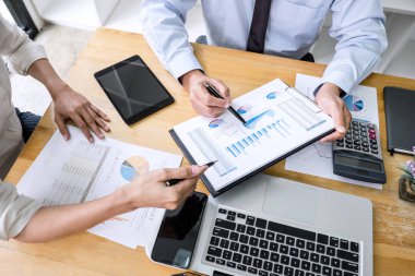 İş dünyası ekibi liderleri, meslektaşlarına sunum ve iş stratejisi üzerinde çalışıyor ve bir tartışma yapıyorlar, grafik ve grafiğe işaret ederek, işbirliği ortaklığının başarısına işaret ediyorlar..