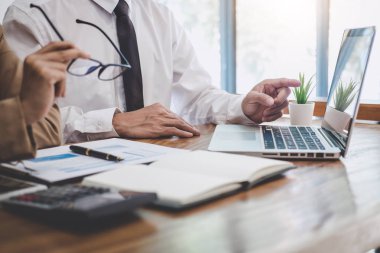 İş takım meslektaşım yeni başlangıç planı ve tartışma için proje bilgilerini dizüstü ve onların başarılı ekip çalışması sonuçlarını dijital tablet ile mali strateji ile çalışan.