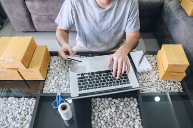 Küçük işletme paketi istemciye sevkıyatın genç adam kutuları açma ve kredi kartı ile ürün satın alma online alışveriş parsel online satın alma sipariş paket ürün pazarlama alınan.