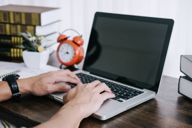 Mutlu rahat Genç Asyalı adam serbest yazar olarak masanın üzerinde bir laptop ve belge rapor kullanarak ev veya küçük ofis çalışma.