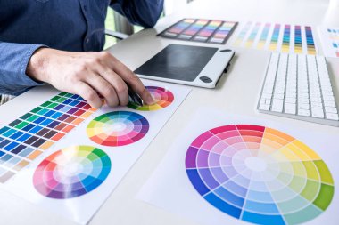 Grafik tablet iş araçları ve aksesuarları ile işyerinde çizim çalışma renk seçimi ve renk örnekleri, Erkek yaratıcı grafik tasarımcı.